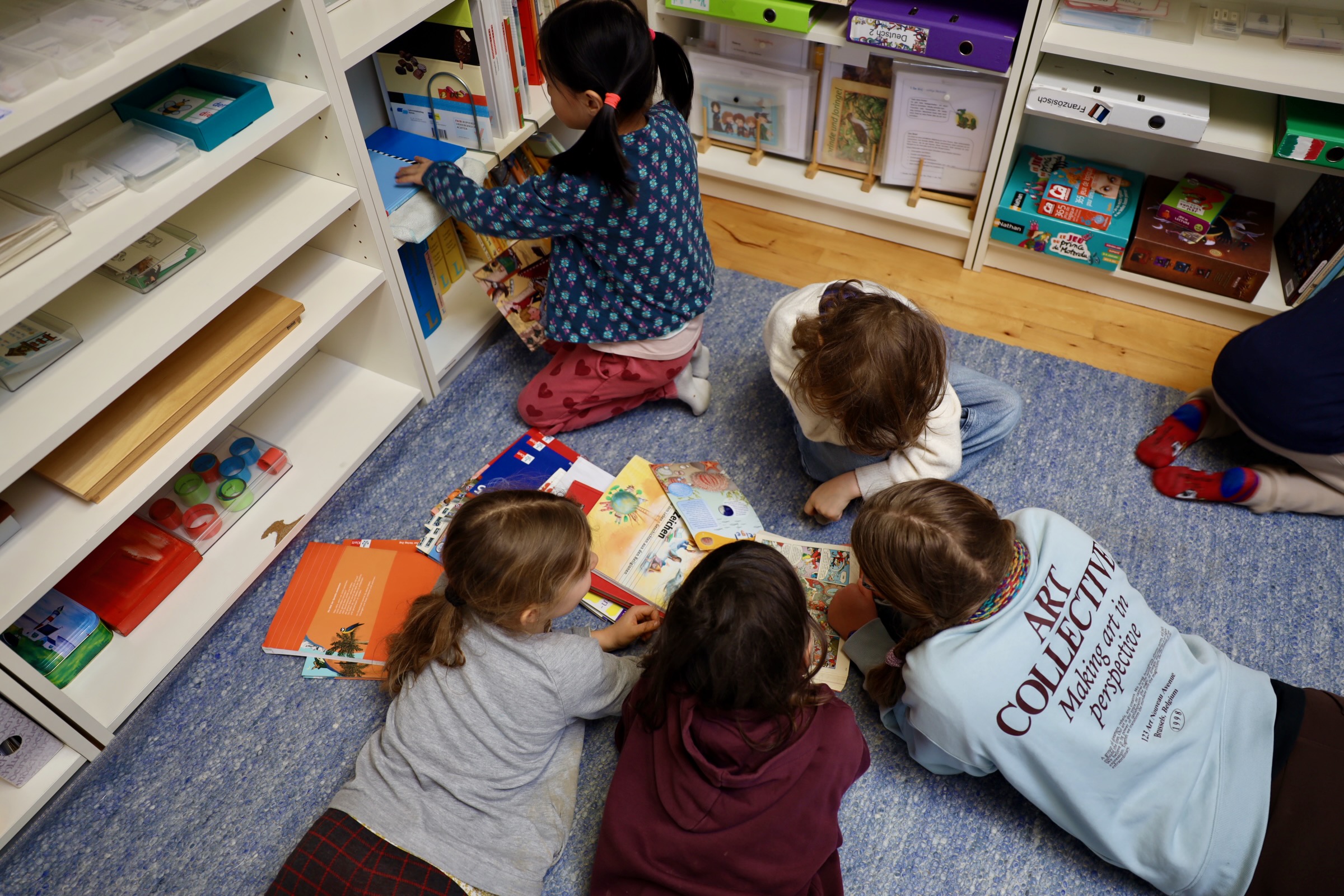 Kinder lesen Bücher in der Montessori Schule Basel