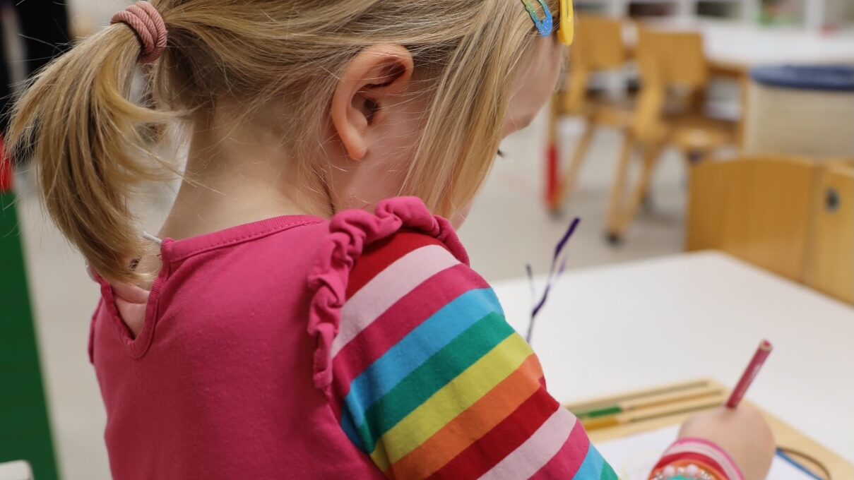 Kind malt mit Farbstiften im Kinderhaus Futura Montessori Basel